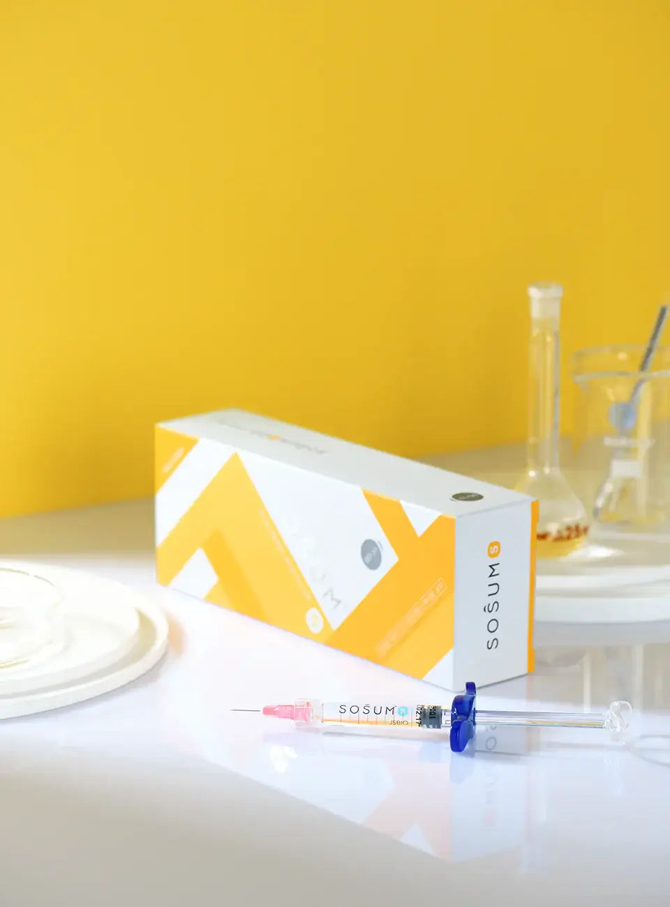 SOSUM S hyaluronic acid gel syringe and packaging on a bright yellow background, ideal for rejuvenation and fine lines.