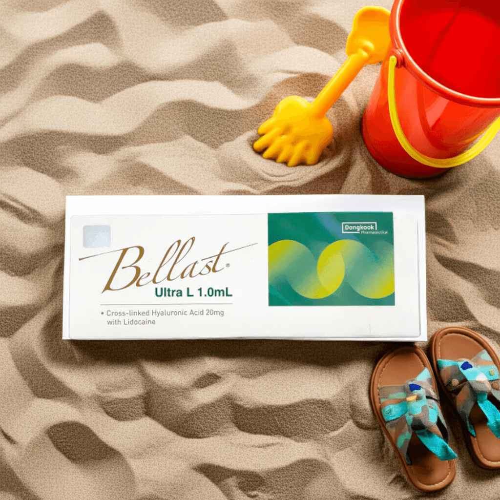 Bellast Ultra L 1.0mL dermal filler packaging on sand, featuring cross-linked hyaluronic acid for fine lines and sculpting.